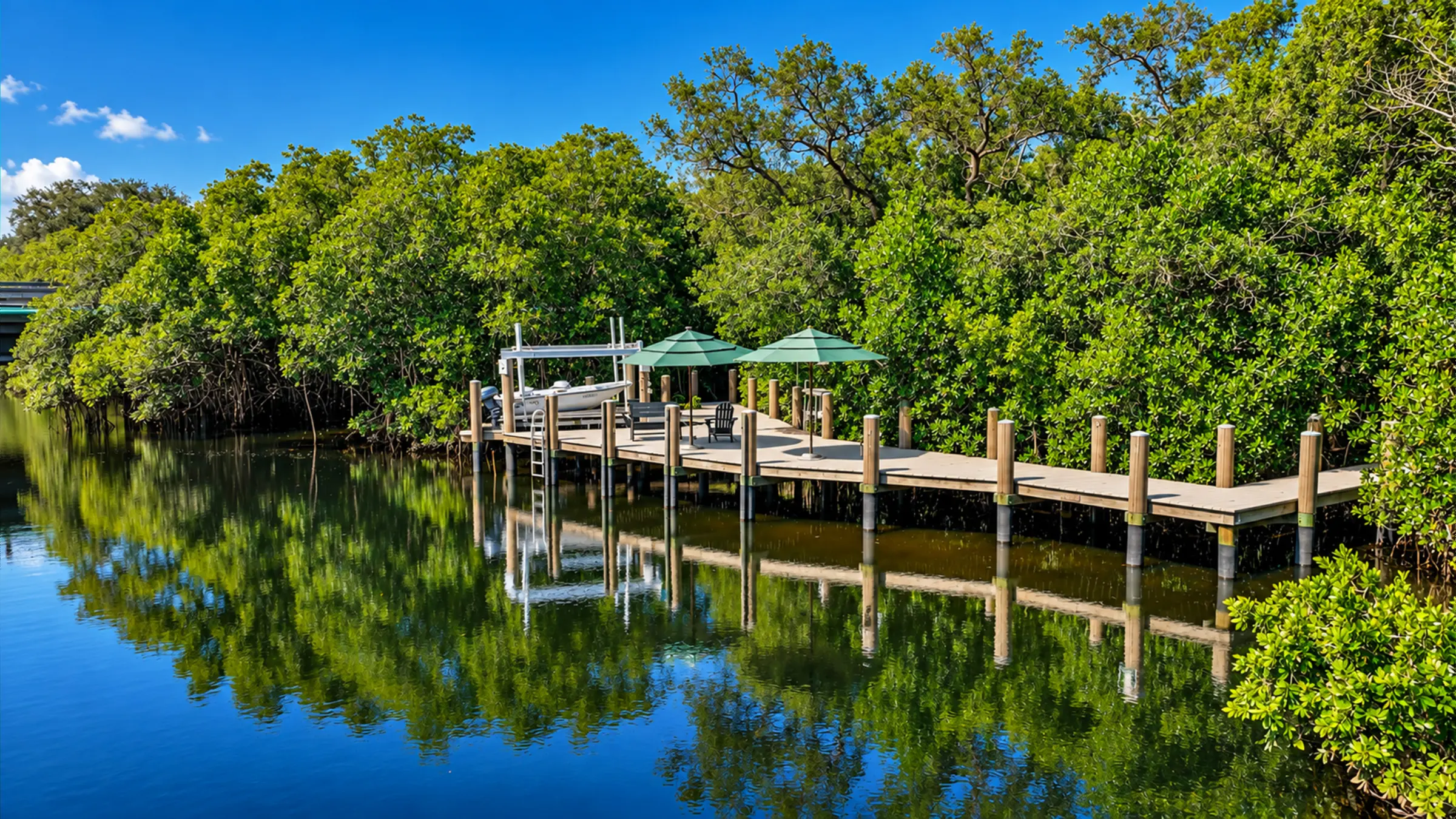 The 900 sq ft dock with boat lift and shade umbrellas on the Cocohatchee River